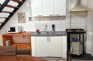 a kitchen with white cabinets and a sink at Depto alquiler por día in Apóstoles