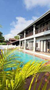 a swimming pool in front of a building at Luang Prabang Meunna Hotel in Luang Prabang