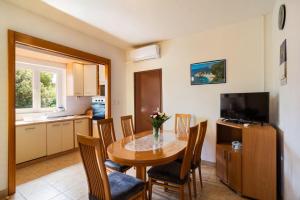 una cucina e una sala da pranzo con tavolo e sedie di Apartment Ivope a Splitska