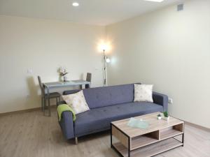 ein Wohnzimmer mit einem blauen Sofa und einem Tisch in der Unterkunft Beautiful View 3 Arco da Calheta - Ilha da Madeira in Arco da Calheta