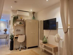 a small living room with a cabinet and a table at "COZY LOFT", TERRACE, PARKING and SWIMMING POOL in Málaga