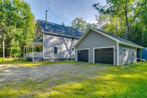 a large white house with a garage at The Locke-ness Pond Cabin in Chesterville! in Wilton