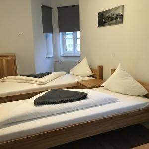 two beds in a room with twothirdsessions at Hotel SINOS in Klagenfurt