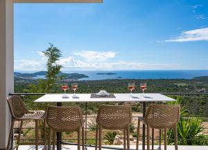 un tavolo con quattro bicchieri di vino su un balcone di Luxury, seaview Villa Grandeca a Rogoznica (Rogosnizza)