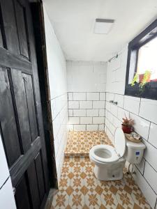 bagno con servizi igienici e pavimento piastrellato. di Villa Elena - Private Room with Shower a Bocas del Toro