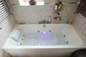 a white bath tub in a bathroom at Quirky comfort cottage in Haslingden +36 photos