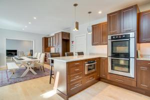 a kitchen with wooden cabinets and a dining room at Furnished Patio Family-Friendly Cape Cod Home! in Centerville +20 photos