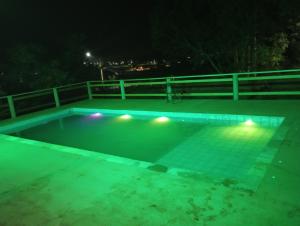 an empty swimming pool at night with lights at Chácara Recanto Águia in Boituva +4 photos