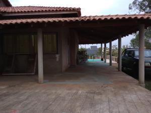 a garage with a car parked under it at Chácara Recanto Águia in Boituva