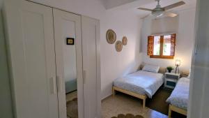 een slaapkamer met twee bedden en een plafondventilator bij Apartamento VERAGREDOS in Villanueva de la Vera +11 foto's