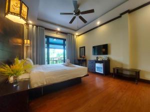 a bedroom with a bed and a ceiling fan at Luang Prabang Meunna Hotel in Luang Prabang +42 photos