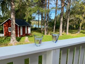 two glasses sitting on a rail on a porch at Sunshine Stuga Bergvik in Gällö