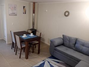 a living room with a table and a couch at Hospedaje Martín Pescador in Villarrica