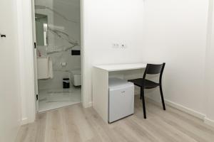 a white desk and a chair in a white room at Guest House J&C in Ponta Delgada +43 photos