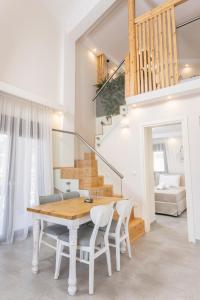 een eetkamer met een tafel en stoelen en een trap bij Ionas Apartments 3 in Nea Skioni