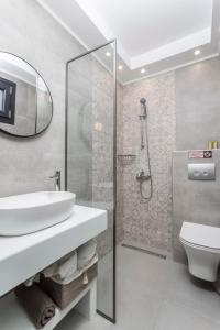 een badkamer met wastafel, douche en toilet bij Ionas Apartments 3 in Nea Skioni +24 foto's