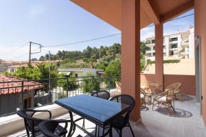 een terras met een tafel en stoelen op een balkon bij Ionas Apartments 3 in Nea Skioni