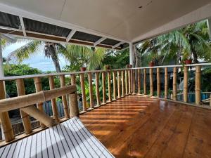 une terrasse couverte avec un banc sur une terrasse en bois dans l'établissement La Villa Elena, à Carenero