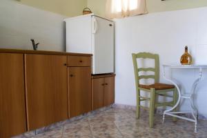 a kitchen with a chair and a refrigerator at Parasporos Village in Adamas