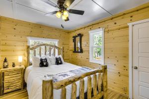 ein Schlafzimmer mit einem Bett mit Holzwänden und einer Decke in der Unterkunft Walk to Water Cozy Cabin in Green Valley Lake! in Green Valley Lake