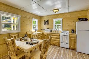eine Holzküche mit Tisch und Kühlschrank in der Unterkunft Walk to Water Cozy Cabin in Green Valley Lake! in Green Valley Lake