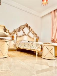 a bedroom with a king sized bed and a chandelier at Une Belle villa meublé à Ennacer in Ariana +11 photos