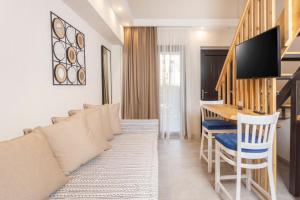 een woonkamer met een bank en een tafel bij Ionas Apartments 4 in Nea Skioni