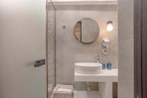 een badkamer met een wastafel en een spiegel bij Ionas Apartments 4 in Nea Skioni +10 foto's