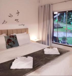 a bedroom with a bed with two towels on it at Recanto Wunderwald Casa Pomerode in Pomerode
