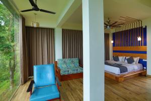 a bedroom with a bed and a blue chair at Roots Munnar in Anachal +59 photos