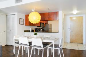 une cuisine et une salle à manger avec une table et des chaises blanches dans l'établissement Amazing Condo Brickell with Ocean-Pool View, à Miami