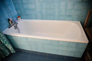 a bath tub with a faucet in a bathroom at Paris Flea Market Comfy Flat in Saint-Ouen +2 photos