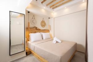 een slaapkamer met een bed en een spiegel bij Ionas Apartments 5 in Nea Skioni