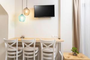 een eetkamer met een tafel en een tv aan de muur bij Ionas Apartments 5 in Nea Skioni