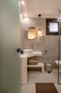 een badkamer met een wastafel en een spiegel bij Ionas Apartments 5 in Nea Skioni +9 foto's