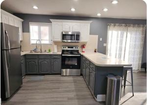 a kitchen with stainless steel appliances and gray cabinets at Vdara Pocono Home in Tobyhanna