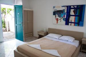 a bedroom with a bed and a painting on the wall at Parasporos Village in Adamas