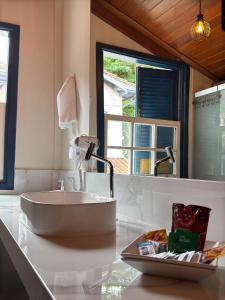 a bathroom with a white sink on a counter at Lofts do Pilar - pousada in Ouro Preto