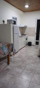 a kitchen with white appliances and a tile floor at Alojamientos Dulce Luz in Villa Elisa