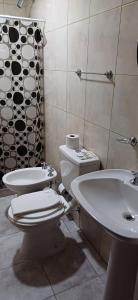 a bathroom with a toilet and a sink and a tub at Alojamientos Dulce Luz in Villa Elisa