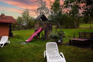 a playground with two white chairs and a slide at Casa Dia in Sohodol