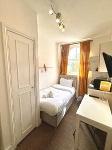 a small room with a bed and a window at London Collection - Bayswater in London