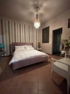 a bedroom with a large bed and a chandelier at Comfortable apartment in Castell'Arquato, 60 m² with garden in CastellʼArquato