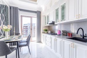 a kitchen with a sink and a table with chairs at Dreamy Luxury Apartment in Tashkent