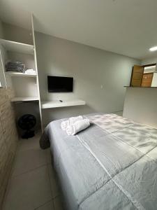 a bedroom with a bed and a flat screen tv at Apto compacto e completo em Petrópolis in Petrópolis