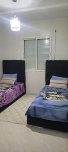 a bedroom with two beds and a window at Tanger in Tangier