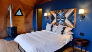 a bedroom with a large bed with a blue wall at Lobo Glamp in Amanalco de Becerra +11 photos