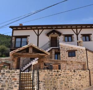 an old stone house with a gate in front at El Capricho de la Serranía II in Tragacete