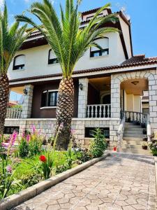 a house with two palm trees in front of it at vivienda de uso turístico Maestro in El Barraco