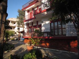 帕埃斯圖姆的住宿－Villa Claudianna Bed & Bike，街道上设有红色阳台的建筑